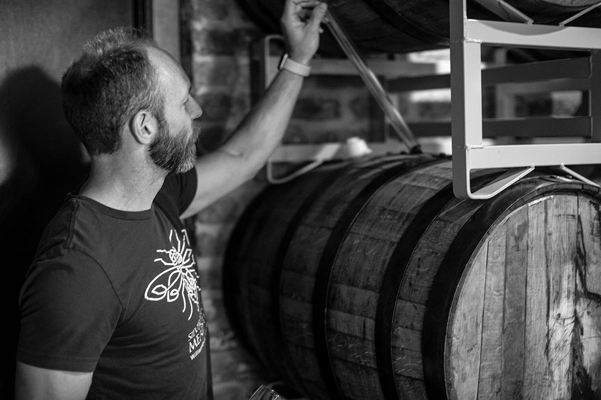 Mead maker sampling from a barrel