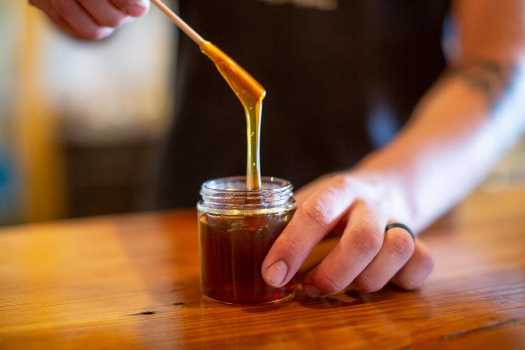 Honey pouring into a jar